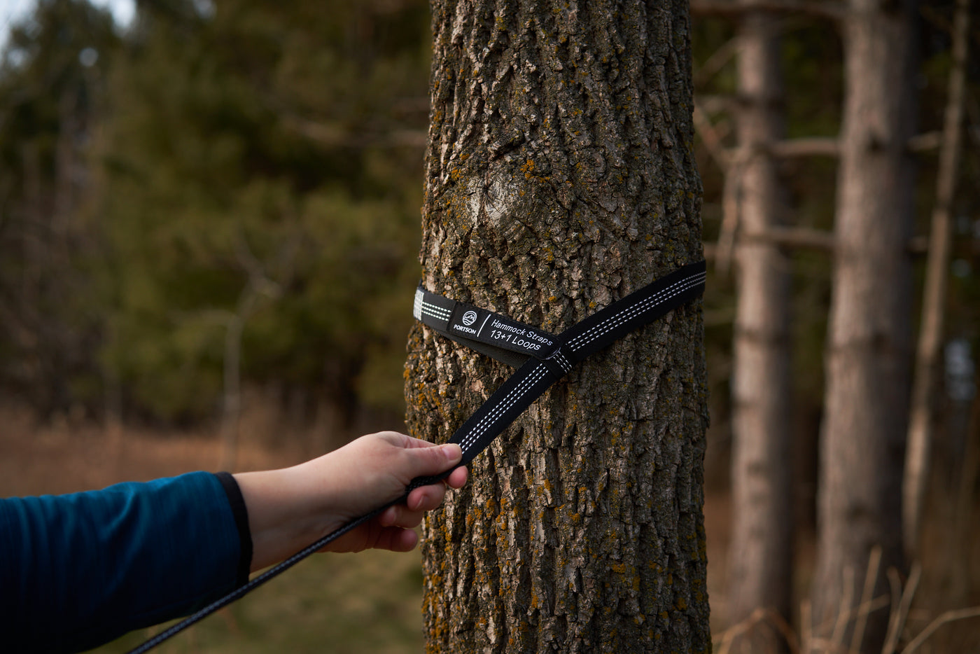 Photo of person wrapping the Portson tree-friendly hammock strap around a tree